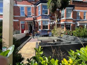 een huis met een bank voor een gebouw bij Monico Guest House in Scarborough