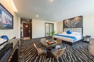a hotel room with a bed and a flat screen tv at Kunming Long Way Hotel in Kunming
