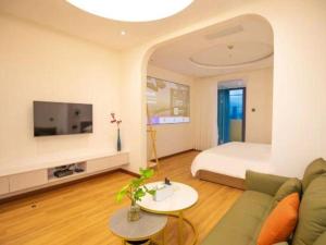 ein Wohnzimmer mit Sofa und Bett in der Unterkunft Silver Art Hotel in Zhuhai
