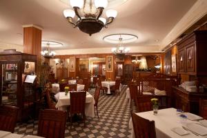 a restaurant with tables and chairs and a chandelier at Hotel Juanito in La Roda