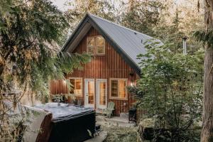 ein Holzhaus mit Whirlpool davor in der Unterkunft Mt Baker Rim Cabin #79 - Hot Tub - Wifi - Pets Ok in Glacier