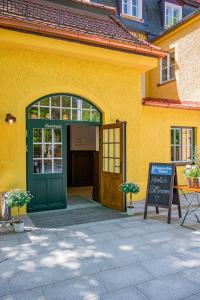 an entrance to a yellow building with a green door at Gutshotel Menterschwaige in Munich