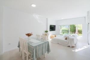 アグア・アマルガにあるCasita Agua Marinaのベッドとテーブルと椅子のある白い寝室