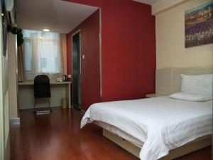 a bedroom with a white bed and a red wall at Hanting Hotel Beijing National Stadium Branch in Beijing