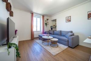 een woonkamer met een blauwe bank en een tafel bij Le paddock in Chagny