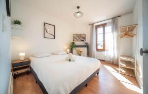 een slaapkamer met een groot wit bed en een raam bij Le paddock in Chagny