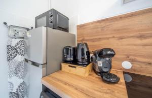 een keuken met een koelkast en een koffiezetapparaat op een aanrecht bij Le paddock in Chagny +10 foto's