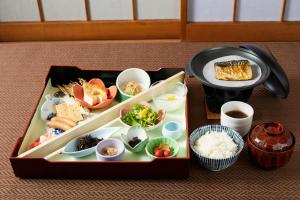 a tray of food with sushi and rice on a table at Ryokan Matsushima in Yokohama
