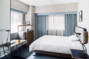 a bedroom with a bed and a desk and a window at Hotel Starplaza Ikebukuro in Tokyo +91 photos