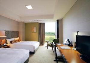 a hotel room with two beds and a desk with a computer at Nippondaira Hotel in Shizuoka
