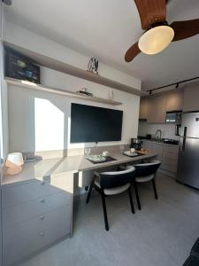 a kitchen with a desk with two chairs and a television at Apto Completo, 3min Estação Higienópolis Mackenzie Consolação in Sao Paulo