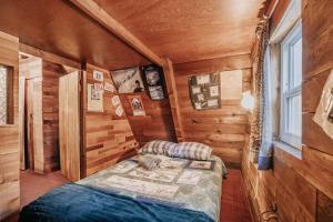 ein Schlafzimmer mit einem Bett in einem Holzzimmer in der Unterkunft Snowline Cabin #54 - Hot Tub - Pets Ok in Glacier