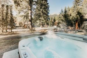 einen Whirlpool im Garten mit Bäumen in der Unterkunft Snowline Cabin #54 - Hot Tub - Pets Ok in Glacier