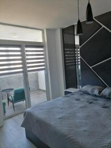 a bedroom with a large bed and a large window at MaFi apartment in Bitola