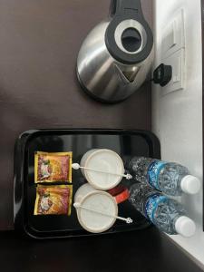 a suitcase with two drinks and two water bottles at Hotel Zamburger Bangsar (Previously Koptown Hotel Bangsar) in Kuala Lumpur