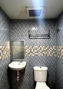 Un baño con lavabo, inodoro y espejo. en Kota Damansara Boutique Hotel, en Kota Damansara 112 fotos más