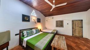 a bedroom with a bed and a ceiling fan at Wild Wadi Wilpattu - Villas with private Plunge Pools in Ilavankulam +190 photos