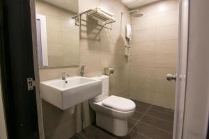 un bagno con un water bianco e un lavandino di V Plus Hotel Ipoh a Ipoh