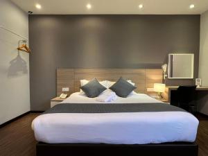 una camera da letto con un letto grande e una televisione di V Plus Hotel Ipoh a Ipoh