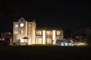 Un gran edificio con una torre de reloj por la noche. en My Home, en Shanghái