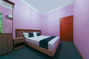 a pink room with a bed and a mirror at Capital O 89876 Safari Hotel in Pasir Bogak +65 photos