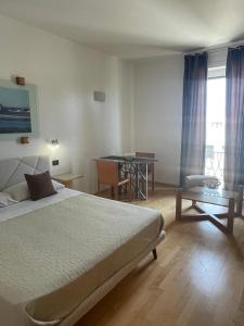 a hotel room with a bed and a table and a table at garibaldi citta' in Trapani