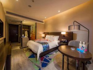 a hotel room with a bed and a table and a couch at Zmax Qingyuan Yiwu Trade City in Qingyuan +66 photos
