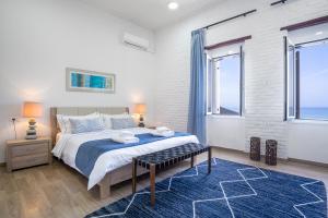 a bedroom with a large bed and a blue rug at Waves - Seaside Escape in Chania Town