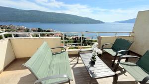 a balcony with chairs and a view of the water at MANONI APARTMANI in Kumbor