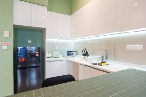クアラルンプールにあるASTORIA Ampang Apt Designer Condoの白いキャビネットとステンレス製の冷蔵庫を備えたキッチン