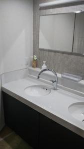 a bathroom with a white sink and a mirror at Kikunoya Ryokan in Kanazawa +17 photos