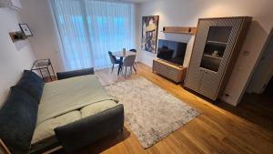 a living room with a couch and a television at MGA Apartment in Bucharest +5 photos