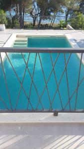 a blue swimming pool with a fence around it at Villa Mala Smišna Poolside Paradise by the Sea in Maslinica