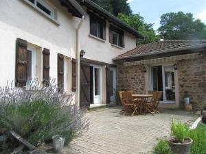 a patio of a house with a table and chairs at Maison dans le Beaujolais vert in Thizy-les-Bourgs