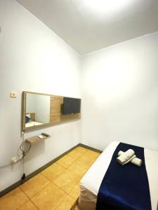 a room with a bed with a mirror and a sink at NamRoom at Tangki Lio in Jakarta
