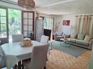 salon ze stołem i kanapą w obiekcie Chalet les Cigalines au calme w mieście Fabrezan