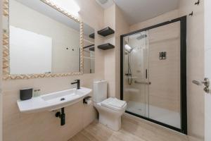 Un baño con inodoro, lavabo y ducha. en Guadalquivir, en Sevilla