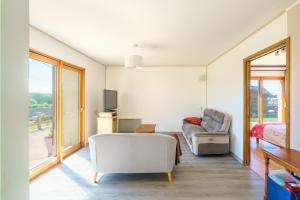 ein Wohnzimmer mit einer Couch und einem Sessel in der Unterkunft La Villa des Vagues - vue mer proche de la plage in Plozévet