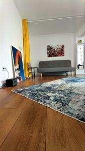 a living room with a couch and a rug at Studio Fortuna Park Residence in Sfântu-Gheorghe +1 photo