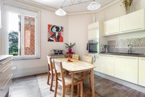 a kitchen with a wooden table and chairs at Spacious 3 bedrooms apartement 135 m & privative parking in Lille