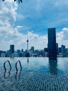 a infinity pool with a view of a city at The KLCC Suites At Axon Residence in Kuala Lumpur
