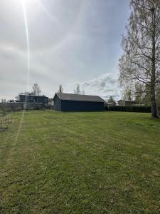 a field of grass with a building in the background at Kastan House in Mustvee