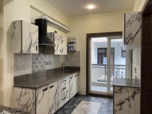 a kitchen with marble counter tops and a window at Rishikesh Comfy Stays in Jāmb