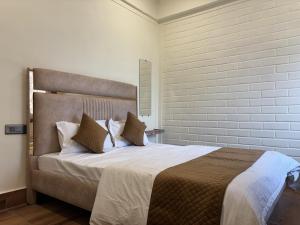 a bedroom with a large bed with white sheets and pillows at Rishikesh Comfy Stays in Jāmb