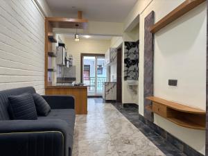 a living room with a couch and a kitchen at Rishikesh Comfy Stays in Jāmb