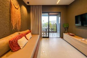 un salon avec un canapé et une télévision dans l'établissement Refúgio em Condomínio Resort na Rota dos Milagres, à Porto de Pedras