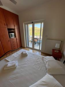 a large white bed in a room with a balcony at Villa Diapori in Tsimándria
