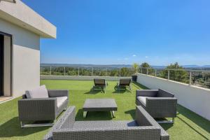 a patio with chairs and a table on a balcony at Bella Vista Cotignac - Piscine Privée in Cotignac