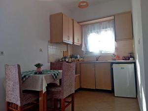 a small kitchen with a table and a refrigerator at Villa Elvid in Ksamil