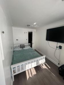 a bedroom with a bed and a flat screen tv at Studio Room in Great Parndon